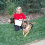 German Shepherd with woman and certificates