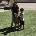 Mother with her son standing next to their family dog
