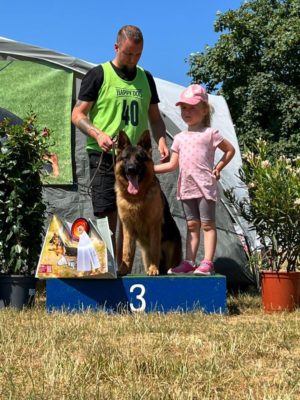 Neros champion dog on podium with owner and little girl.