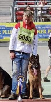 Kia, the German Shepherd standing with his trainer, winning a ribbon for World Championship in Germany.